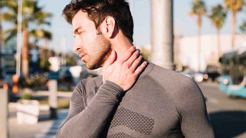 homme sportif étirement cou blessé