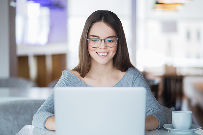 Jeune femme à lunettes devant un ordinateur